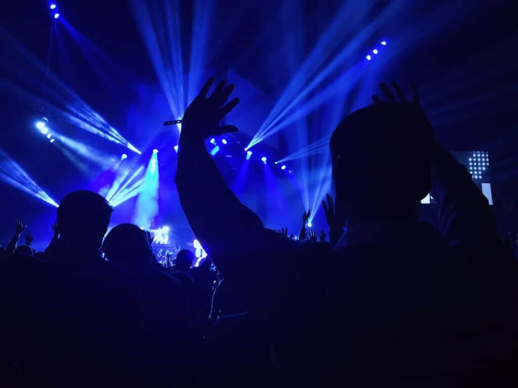 groupe de personnes à l'intérieur du dôme regardant un concert de rock avec des effets lumineux spectacualires